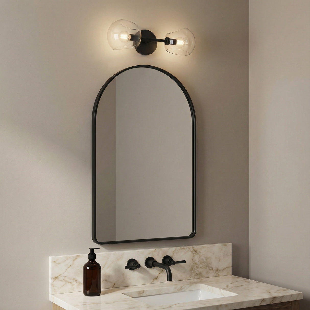 Flynn 2 Light Wall Sconce, Matte Black with Clear Glass styled in a Modern Bathroom with marble vanity.