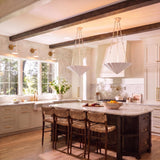 A transitional kitchen features two Cora Pendant 23", Textured White fixtures suspended over a dark wood island with a marble countertop and dark ceiling beams.