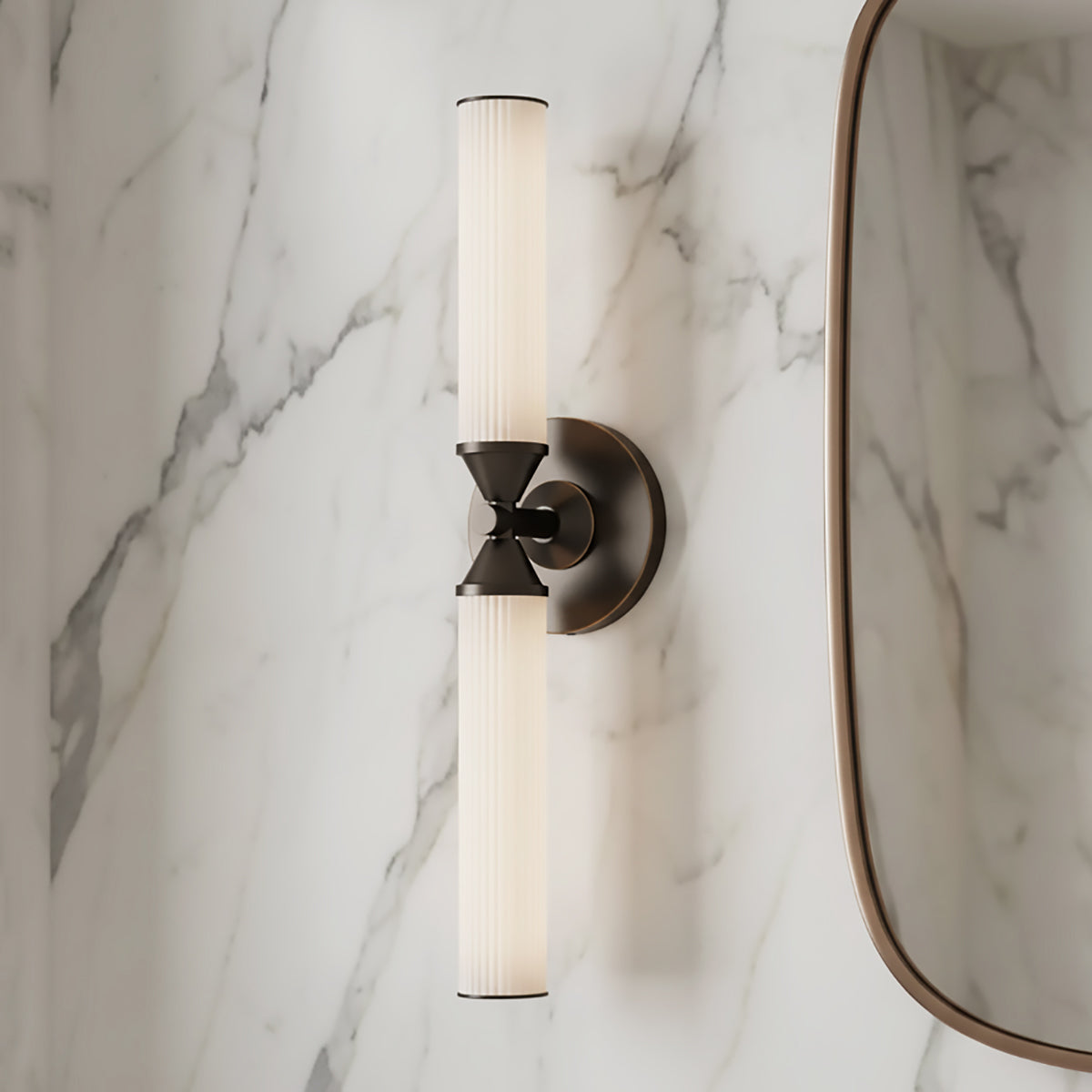 Blain LED Wall Sconce 22", in Urban Bronze finish, shown next to a vanity mirror with a marble slab backsplash.