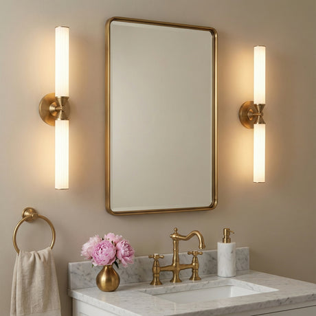 Blain LED Wall Sconce 22" tall shown mounted vertically next to aged brass vanity mirror
