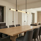 Linear pendant, Matte Black linear design in a Transitional Dining Room with a light wood dining table.