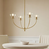 Bella 4 Light Chandelier in brass close-up hung above a small dining table in a bright room.
