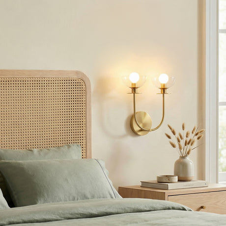 Bella 2 Light Wall Sconce, Brushed Brass styled in a Modern Bedroom with light wood and cane accents.
