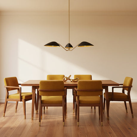 Jade 3 Light Chandelier 36, Matte Black and Antique Brass - A dining room with a chandelier over a wooden table with yellow chairs.