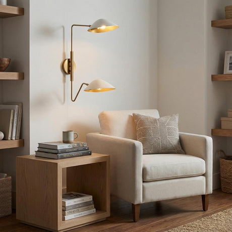 Double Swing Arm Sconce, White and Brass linear wall sconce in a Modern Living Room with a cream armchair and light wood side table.