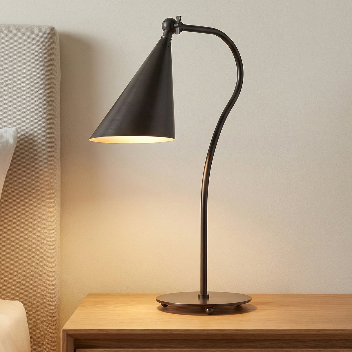 Faye Adjustable Table Lamp, Old Bronze geometric Table Lamp in a Modern Bedroom with a light wood nightstand and upholstered headboard.