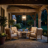 Bedford Antique Black Iron geometric Outdoor Hanging in a Farmhouse Outdoor with wooden armchairs and a stone table.