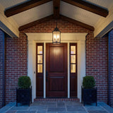 Bedford Outdoor Hanging Light, Antique Black Iron geometric Outdoor Hanging in a Colonial Outdoor with a dark wood door and brick walls.