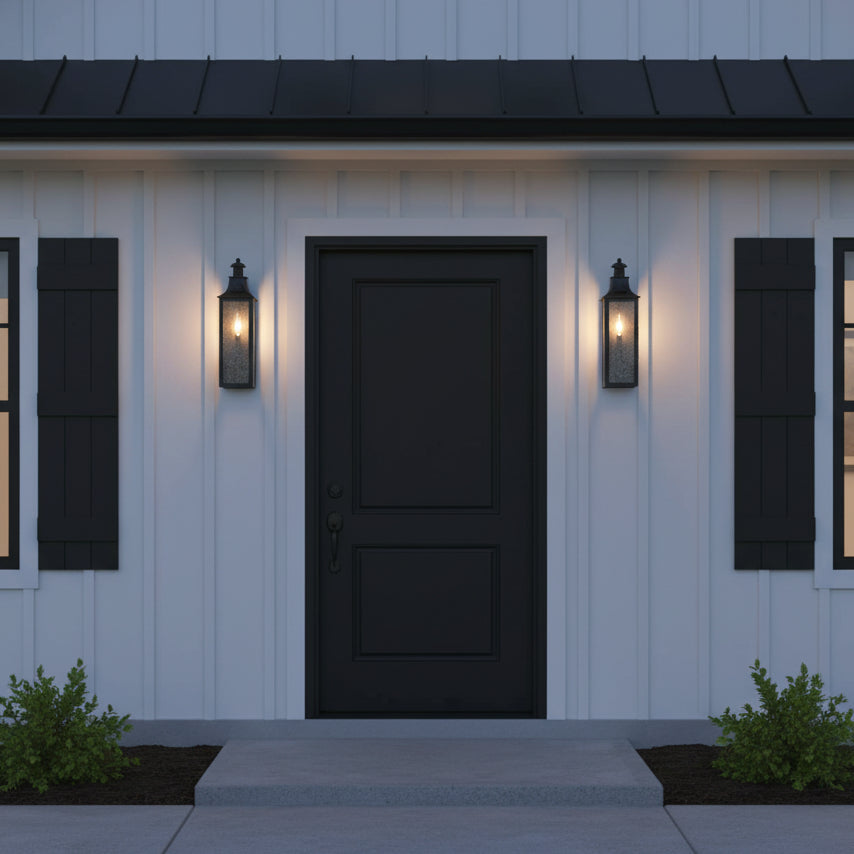 Bedford Outdoor Wall Light, Small 18" Antique Black Iron - Two black sconces flanking a black front door, on a modern farmhouse style home with black metal roof.