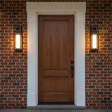 Two Small Waverly LED Outdoor Wall Lights, flanking a wooden front door on a brick house.