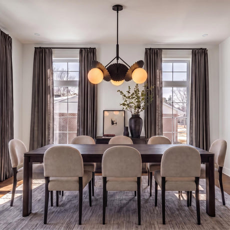 A contemporary dining room featuring a Lydia 3 Light Pendant 34", Black and Opal Glass over a dark wood table with beige upholstered chairs and charcoal curtains.