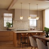 Modern kitchen with wooden cabinets, three Lydia 14" pendant lights, and a dining area.