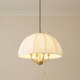 Brushed Brass with Cream Fabric Shade linear pendant in a Transitional Living Room with elegant crown molding.