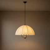 Antique Bronze & Matte Black cream fabric scalloped pendant in a Transitional Living Room with a warm beige wall.