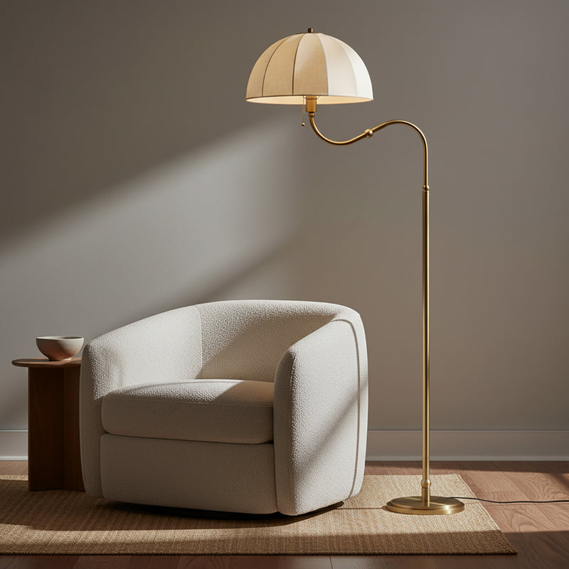 Trudy Floor Lamp, Brushed Brass - Floor lamp next to a chair and side table in a living room setting