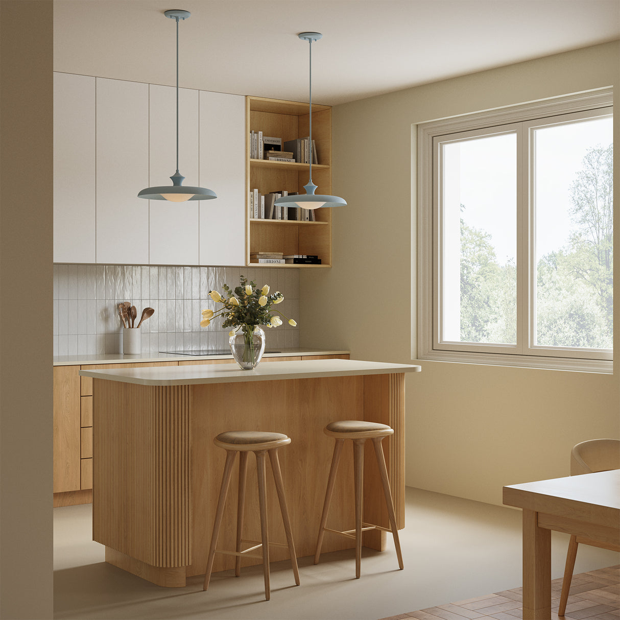 Two Mabel pendant lights in baby blue in a small, bright kitchen above a two-seater island.
