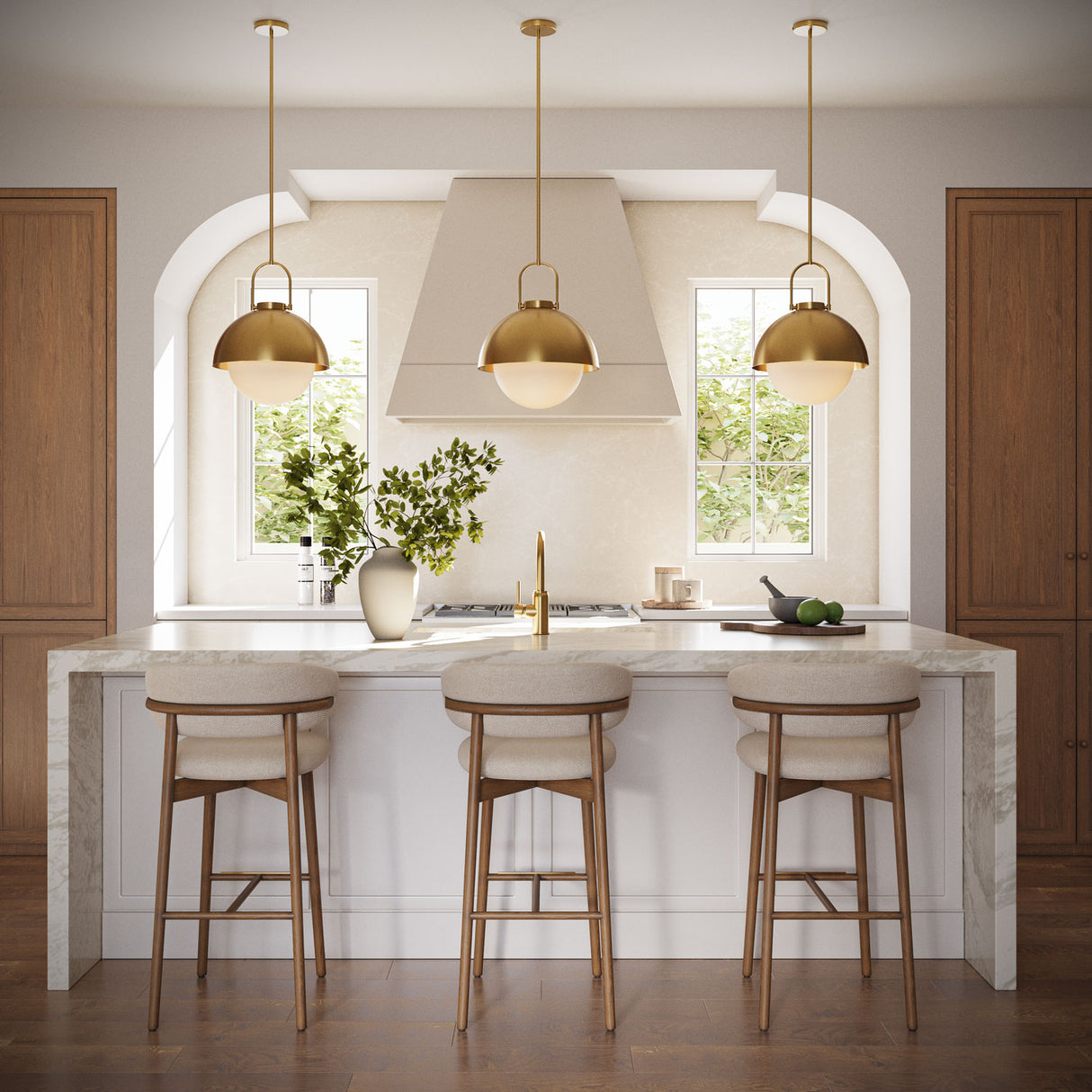 Three Solene Pendants 16", Antique Brass and Opal Glass, hung above a kitchen island with stone waterfall countertops and three bar stools. 