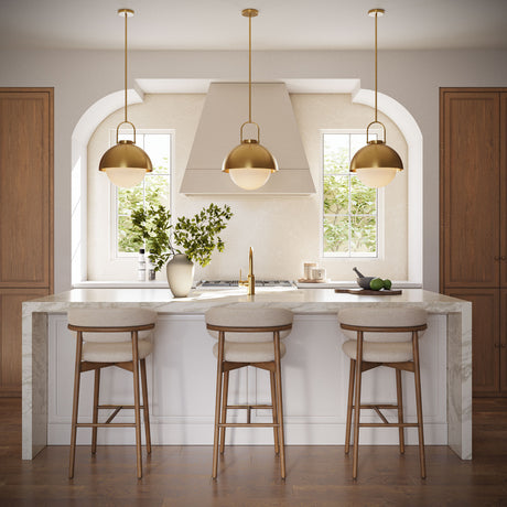 Three Solene Pendants 16", Antique Brass and Opal Glass, hung above a kitchen island with stone waterfall countertops and three bar stools. 