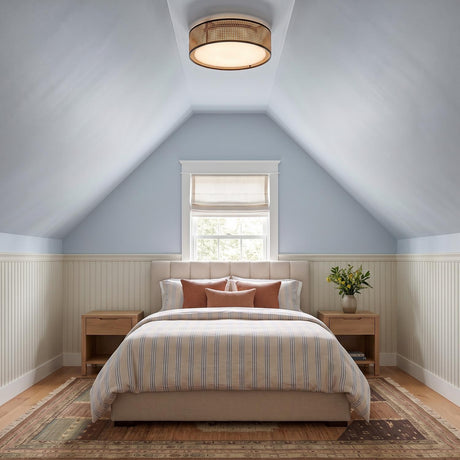 A coastal bedroom with the Amaris LED Flush Mount in cane and matte black on a sloped blue ceiling above a striped bed and white wainscoting.