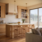 Two Addison Extra Large Pendant lights in Brass and clear glass, shown above a kitchen island in a warm oak wood modern kitchen.