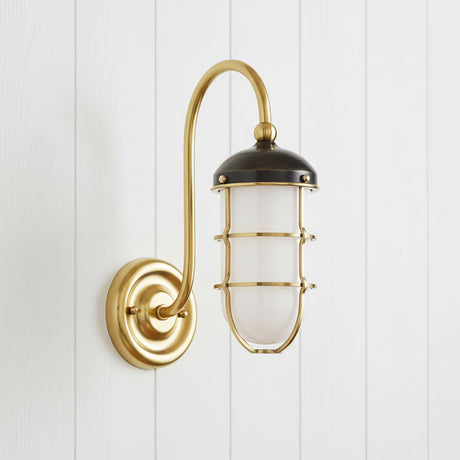 Sawyer Wall Sconce 13", Aged Brass and Distressed Bronze - A single wall sconce with a brass arm and bronze shade is mounted on a white wood panel wall.