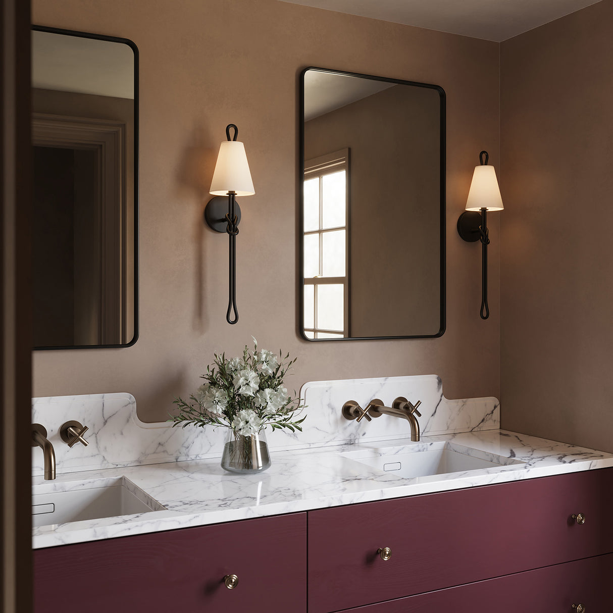 Two Archer 24" tall Wall Sconces are shown with a marble topped double vanity in a bathroom with earth toned walls.