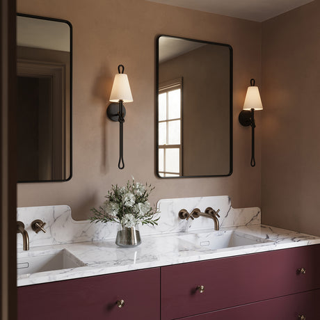Two Archer 24" tall Wall Sconces are shown with a marble topped double vanity in a bathroom with earth toned walls.