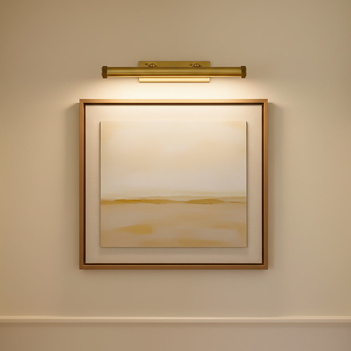 Abstract painting in a gold frame on a beige wall illuminated by the Graham Large 24.5" Picture Light in aged brass.