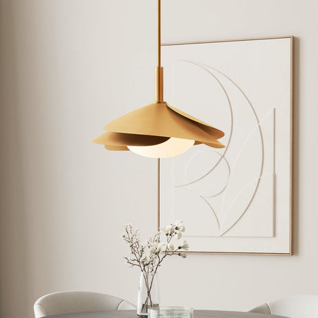 Lola Pendant in Gold Leaf with Milk Glass is shown in a bright dining area in front of modern art.