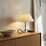 Odin Table Lamp, Forged Iron linear Table Lamp in a Modern Living Room with a wooden credenza and textured wall.