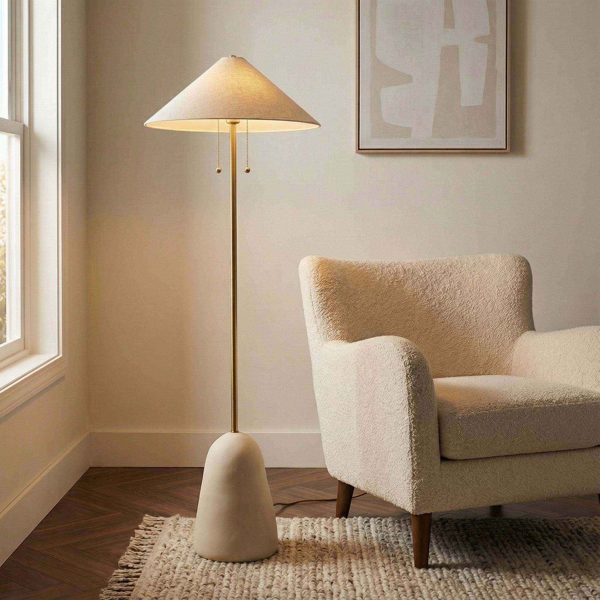 Rhea Floor Lamp, Aged Brass & Cream geometric floor lamp in a Modern Living Room with a cream boucle armchair.
