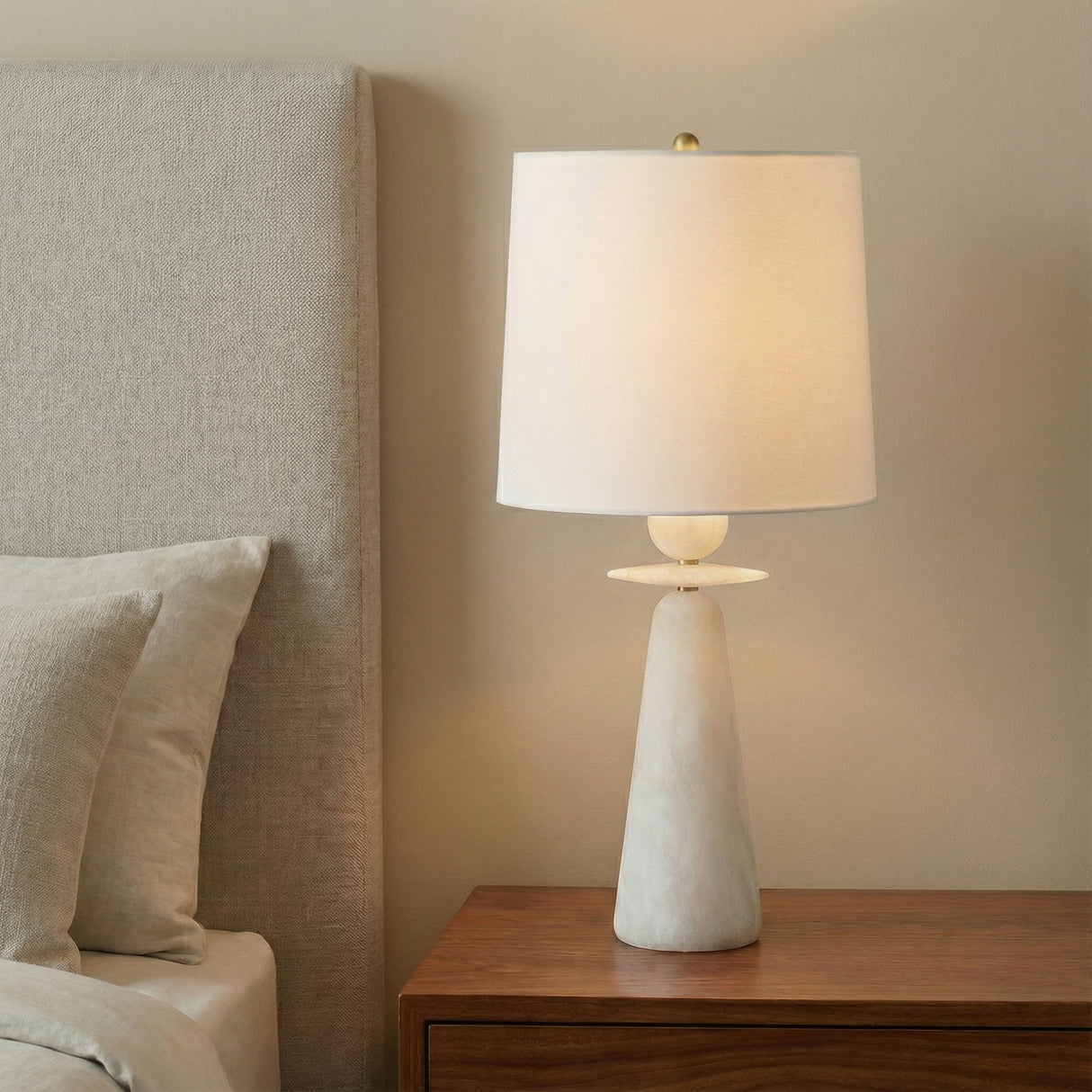 Juliet Table Lamp, Alabaster with Brass Accents in a Modern Bedroom with textured headboard.