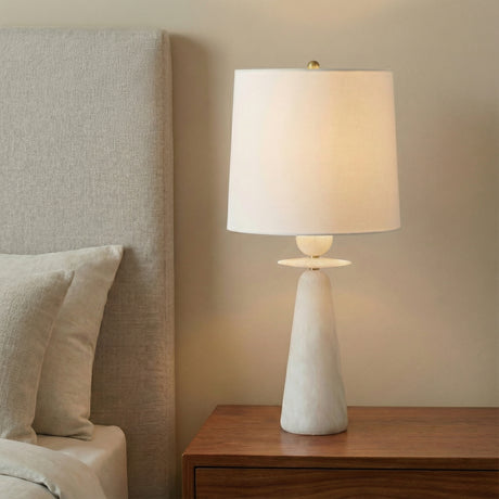 Juliet Table Lamp, Alabaster with Brass Accents in a Modern Bedroom with textured headboard.