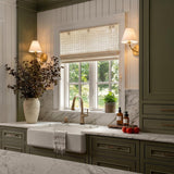 A modern farmhouse kitchen featuring two Morgan Wall Sconce 11", Aged Brass fixtures flanking a window over a white apron-front sink and olive green cabinetry.
