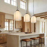 Lana Pendant 14", Old Bronze and Opal Glass geometric pendant in a Modern Farmhouse Kitchen with a stone island and wood cabinets.