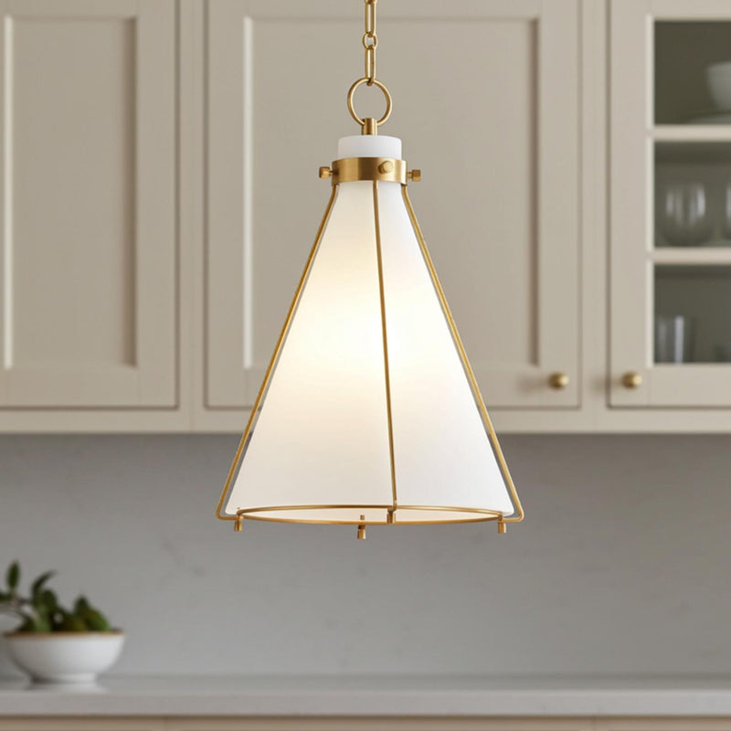 A transitional kitchen featuring the Leo Pendant 16", Aged Brass and Opal Glass suspended over the island with a white marble countertop and beige shaker cabinets.