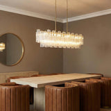 Grace Linear Chandelier 52", Brass and Clear Glass linear chandelier in a Contemporary Dining Room with cognac leather chairs.