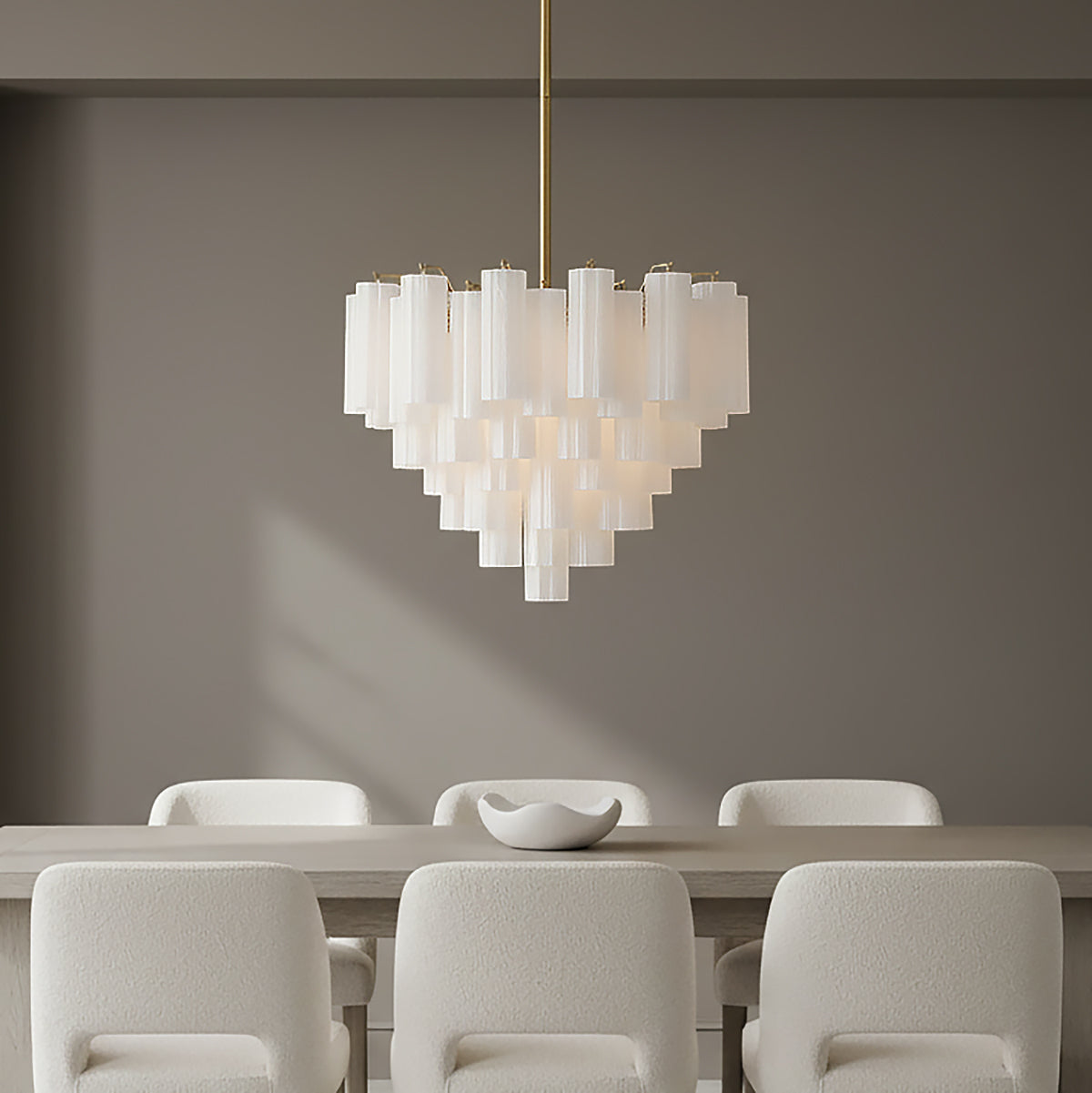 Grace 12 Light Chandelier 27, Brass with White Glass - A brass and white glass chandelier hangs over a dining table with six white chairs.