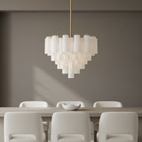Grace 12 Light Chandelier 27, Brass with White Glass - A brass and white glass chandelier hangs over a dining table with six white chairs.