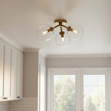 A transitional kitchen features the Gurt 3 Light Semi-Flush 18", Aged Brass flush mount along the ceiling beside white shaker cabinets and a white subway tile backsplash.