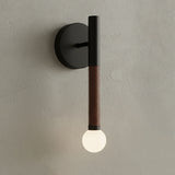 Modern wall light fixture with black and brown design on a neutral wall.