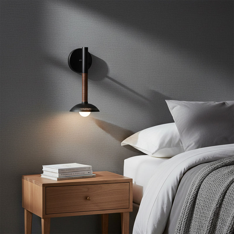 Sheila 1 Light LED Wall Sconce 14, Matte Black and Walnut - A wall sconce is installed above a bedside table with books in a bedroom setting.
