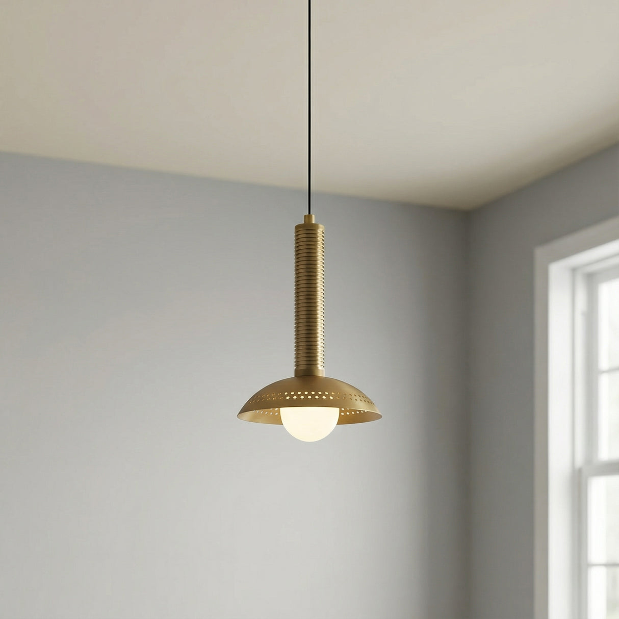 Sheila LED Pendant 9", Brushed Brass geometric pendant in a Modern Living Room with plain grey walls.
