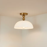 Archie Flush Mount 12", Brushed Brass and Opal Glass - A close up of the fixture against a white ceiling