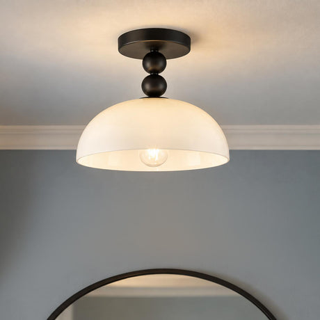 A transitional foyer features an Archie Flush Mount 12" in matte black with an opal glass shade installed above a round dark-framed mirror.