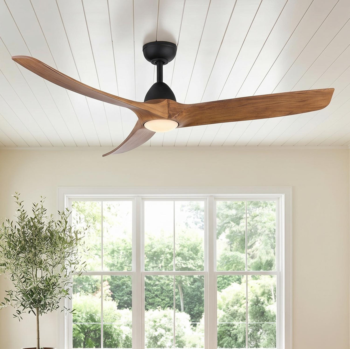 A modern farmhouse living room with the Sedona matte black and natural wood ceiling fan on a white shiplap ceiling overlooking a large bright window.