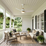 A modern farmhouse porch with white siding and black shutters features the Kent LED Outdoor Ceiling Fan with Light 42", Brushed Brass and White on the shiplap ceiling.