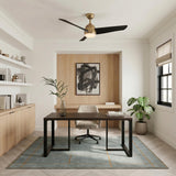 A contemporary office with the Lorain LED Ceiling Fan 54" in brushed brass and matte black mounted over a dark wood desk and light wood built-ins.
