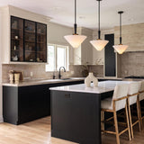 A transitional kitchen with three matte black pendants featuring frosted glass shades suspended over a white quartz island with black cabinetry and a marble backsplash.