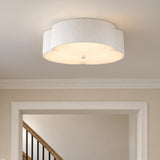 A transitional foyer featuring the Shyla Flush Mount 14", Antique White fixture with a scalloped fabric shade mounted above a cased opening leading to a wooden staircase.